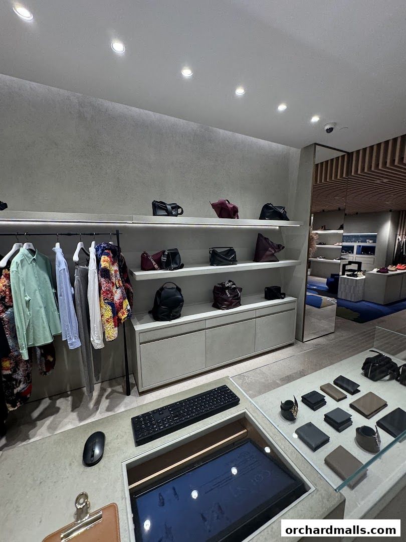 Interior of a luxury fashion store showcasing handbags and apparel on shelves and racks.