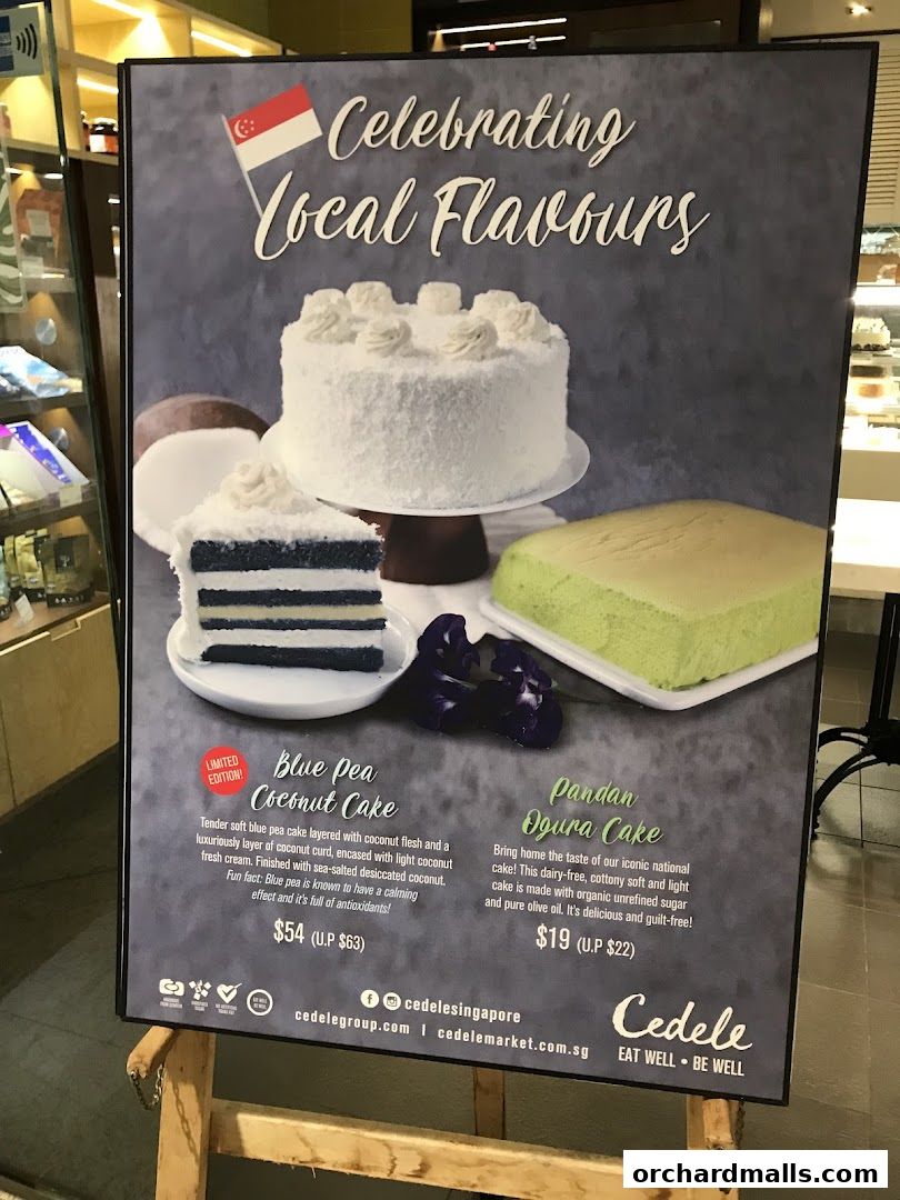 A poster advertising Cedele's 'Celebrating Local Flavours' cakes, featuring Blue Pea Coconut Cake and Pandan Ogura Cake.