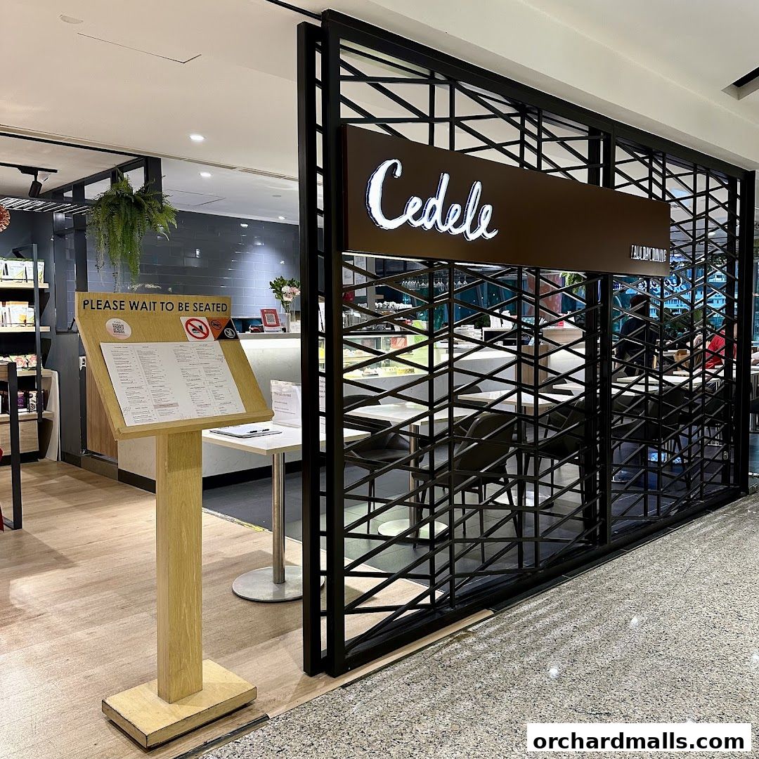 The entrance of Cedele All Day Dining with a menu stand and seating visible inside.