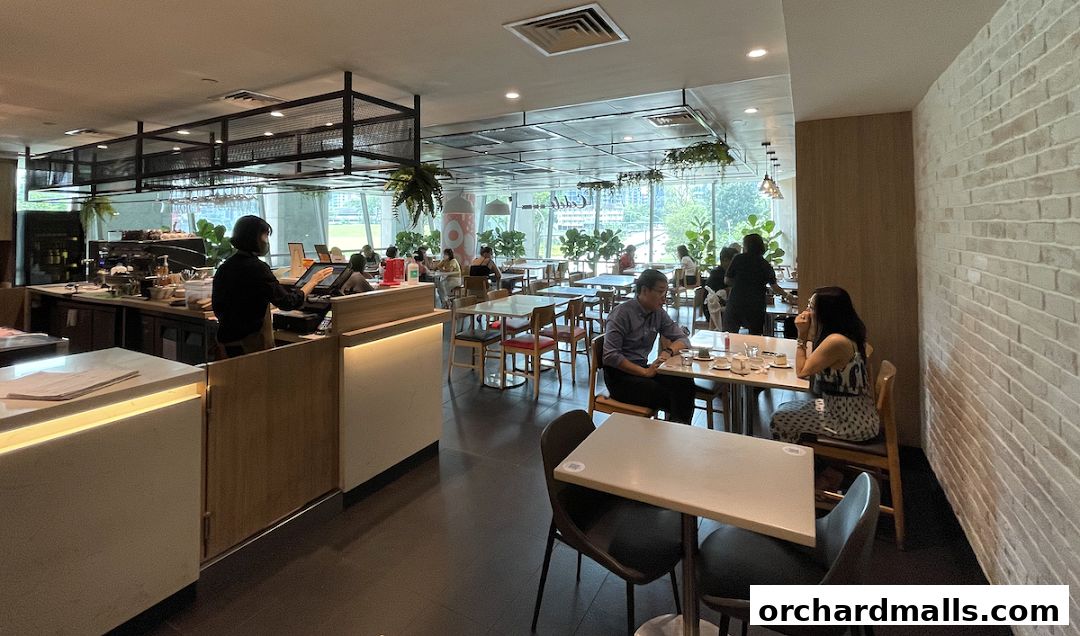 Interior view of a busy cafe with customers dining and staff at the counter.