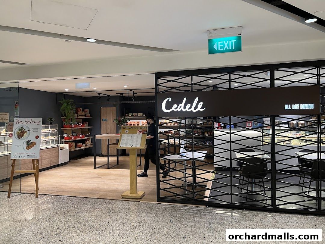 The entrance of Cedele All Day Dining, showcasing its display of food and seating area.