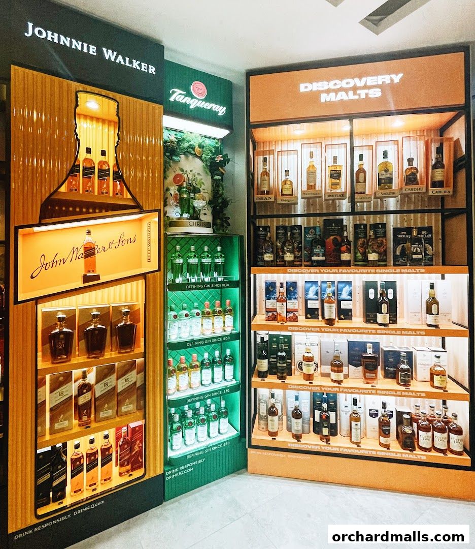 A well-lit display of various premium spirits, including Johnnie Walker, Tanqueray gin, and a selection of malts.