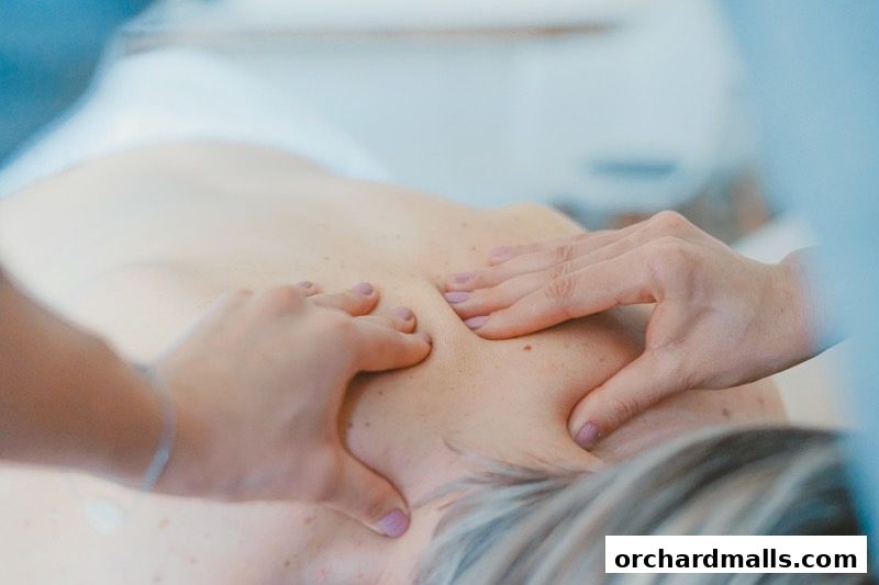 Close-up of hands giving a therapeutic massage to a person's back.