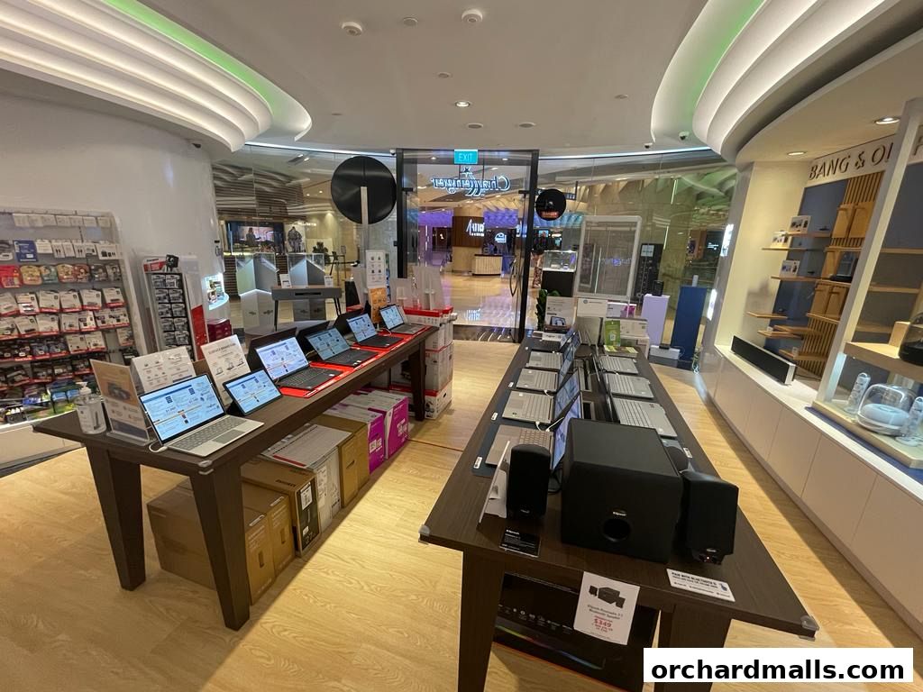 Interior view of a Challenger electronics store showcasing laptops and audio equipment.