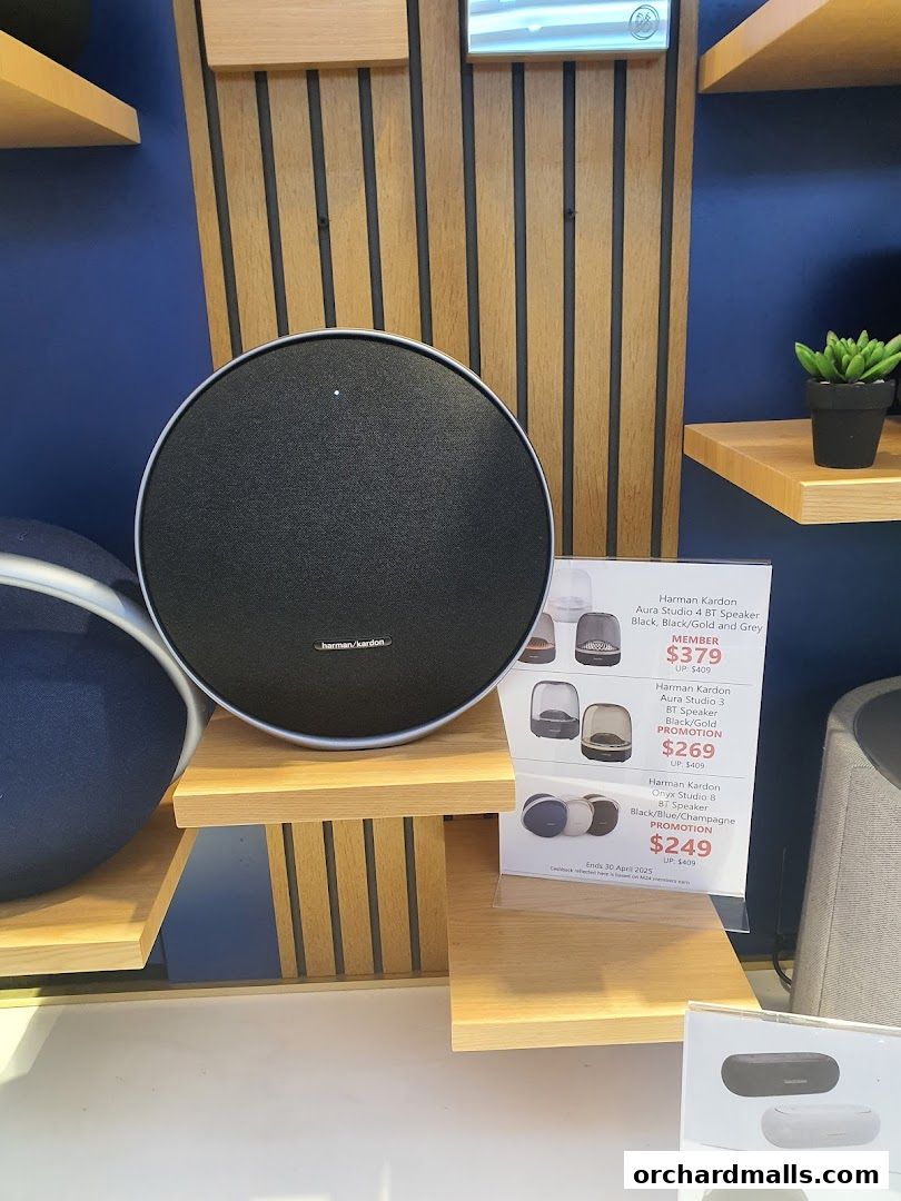 A display of Harman Kardon speakers with promotional pricing information.