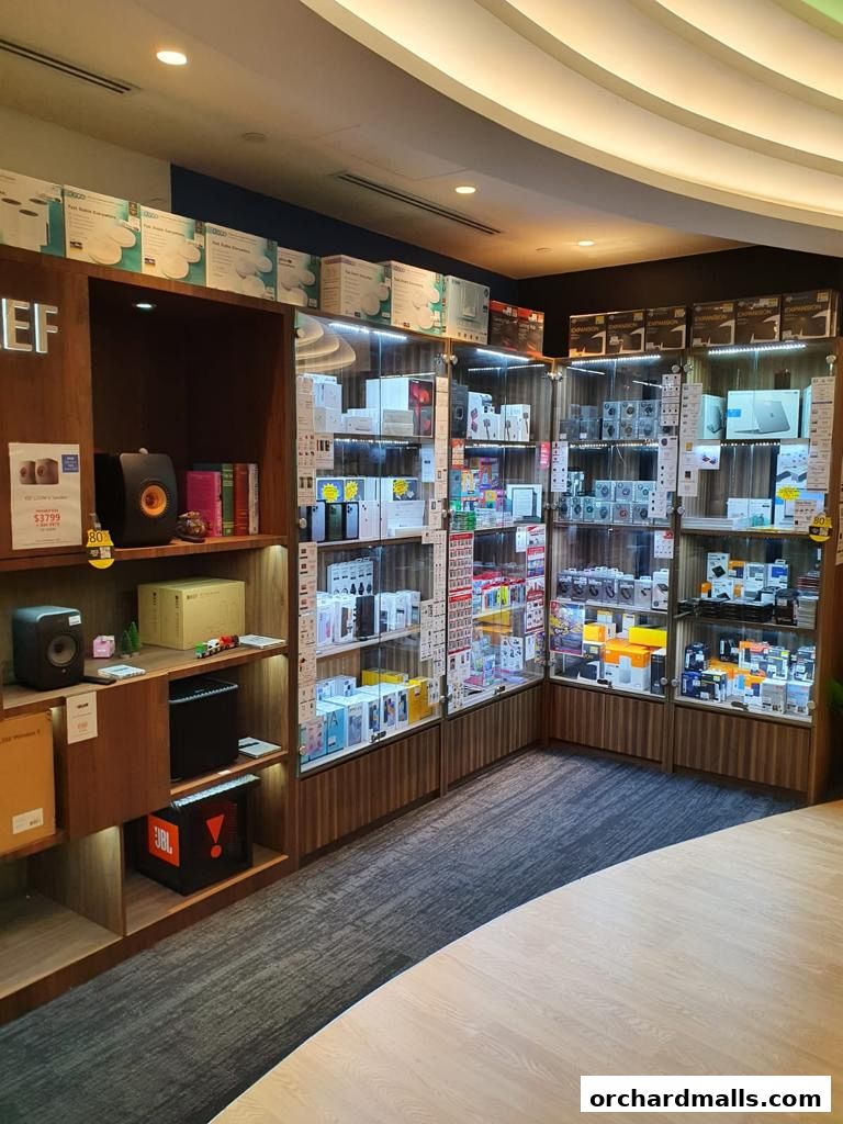Interior view of a well-lit electronics store showcasing various gadgets and accessories on shelves and in display cases.