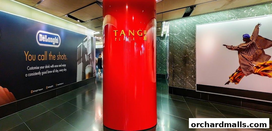 A bright red pillar stands in a modern hallway with advertisements on the walls.