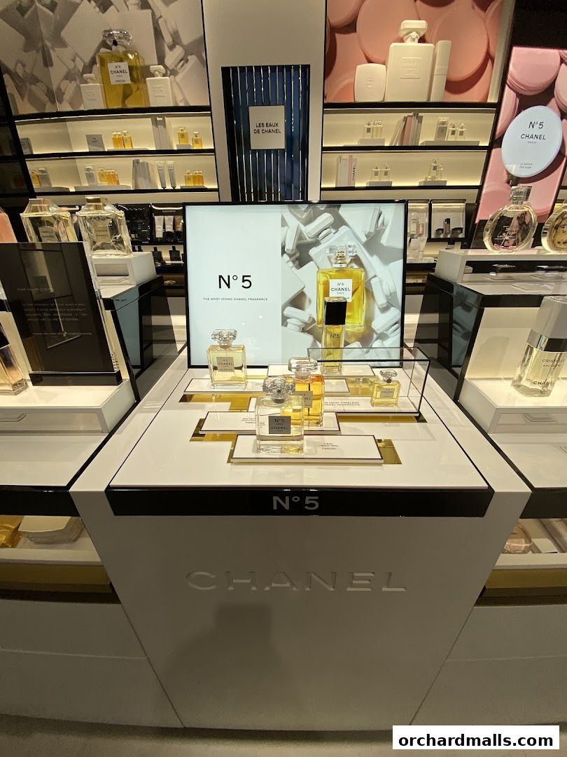 A display of Chanel N°5 perfume bottles and other beauty products on shelves.