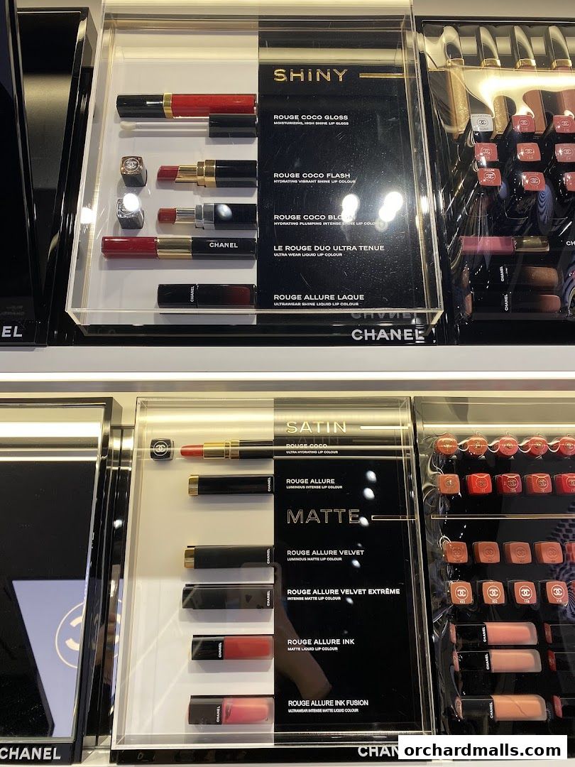 A display of various Chanel lipsticks and glosses, categorized by finish.