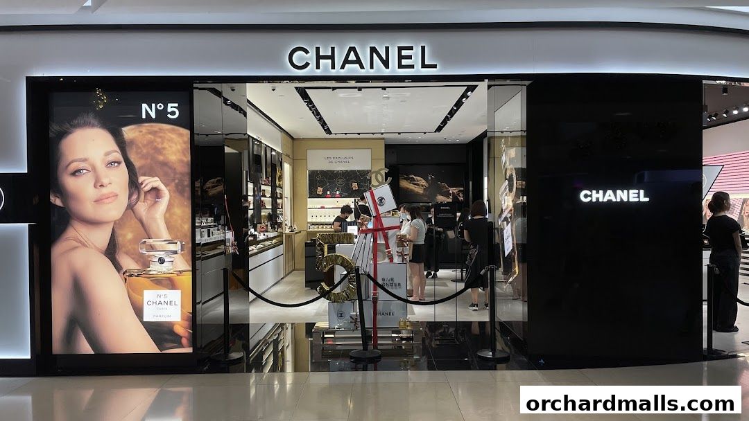 The elegant Chanel Beauty Boutique entrance features a striking N°5 perfume advertisement and a display of luxury products.