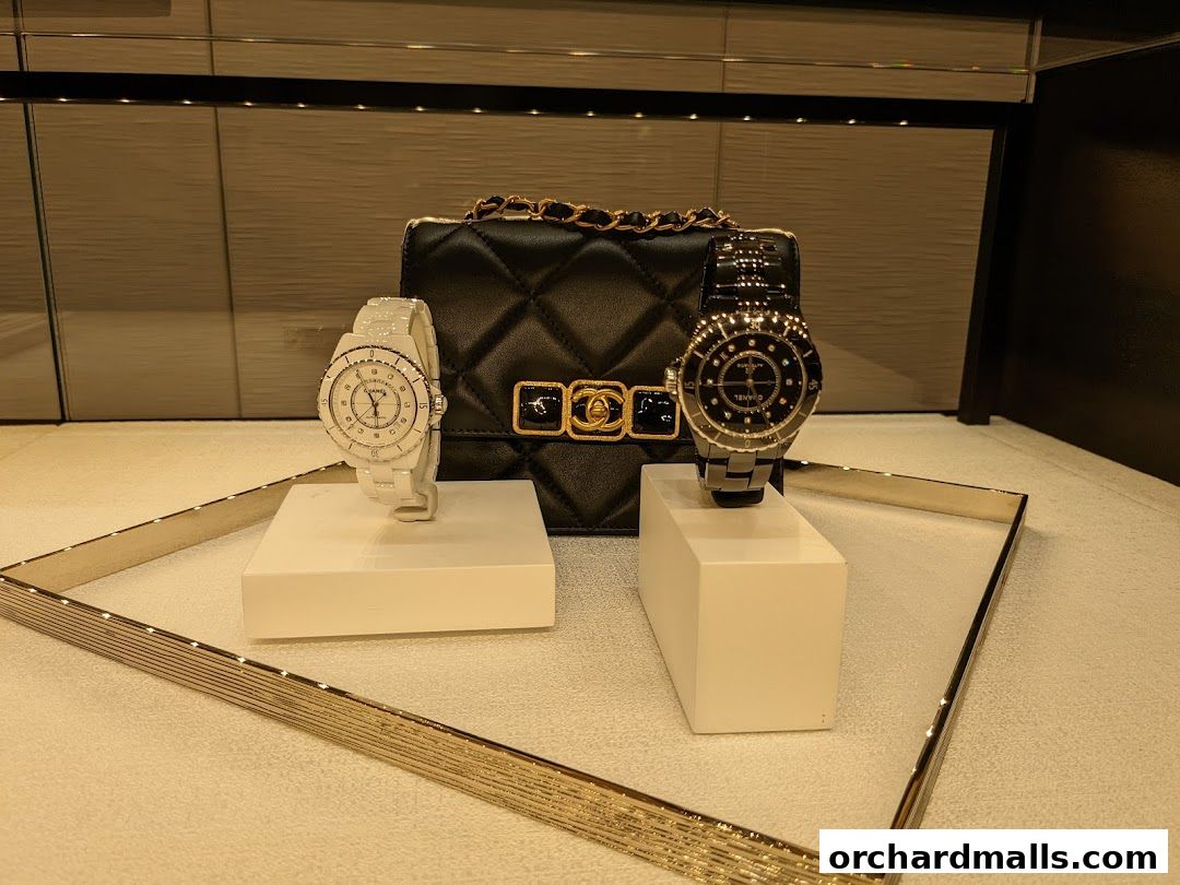 Chanel display featuring a black quilted handbag and two watches.