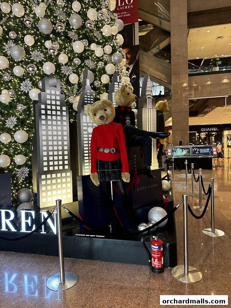 A festive holiday display with teddy bears and a Christmas tree in a shopping mall.