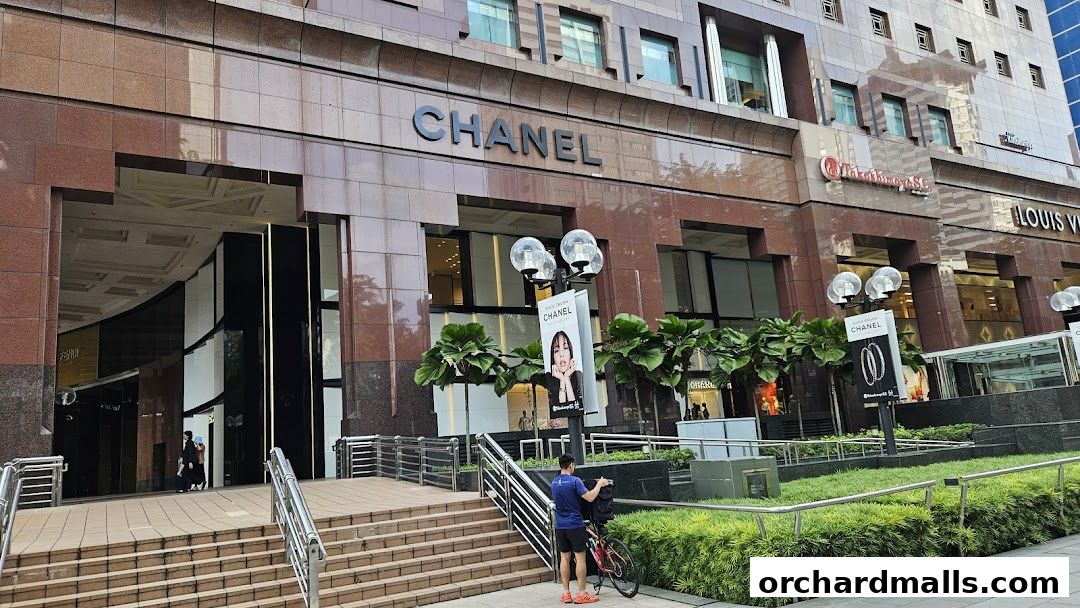 The exterior of a luxury Chanel store with its prominent logo and display banners.