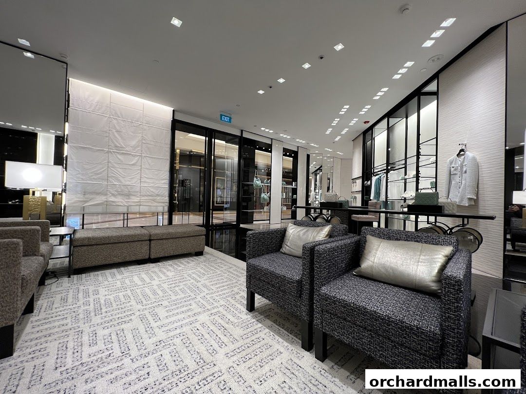 Interior view of a luxurious Chanel boutique with seating and displayed fashion items.