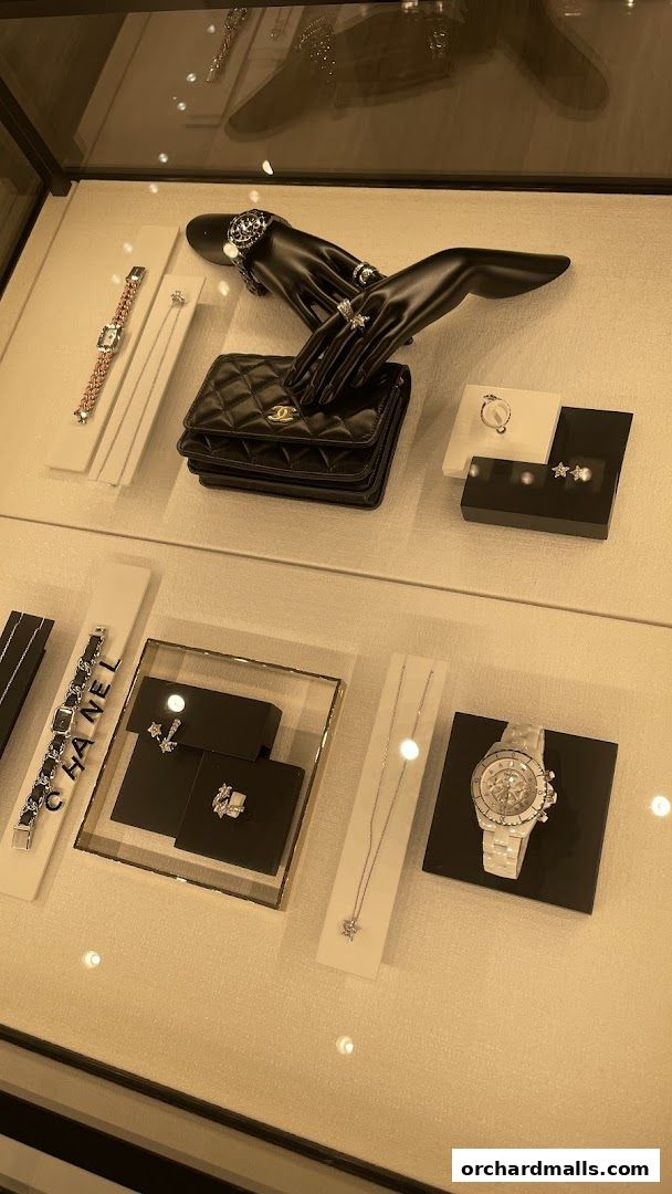 Chanel watches and fine jewelry displayed in a well-lit display case.