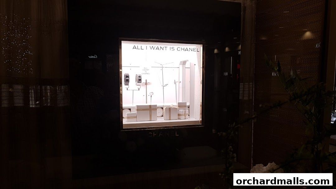 Chanel watch and fine jewelry store window display with gift boxes and watches.
