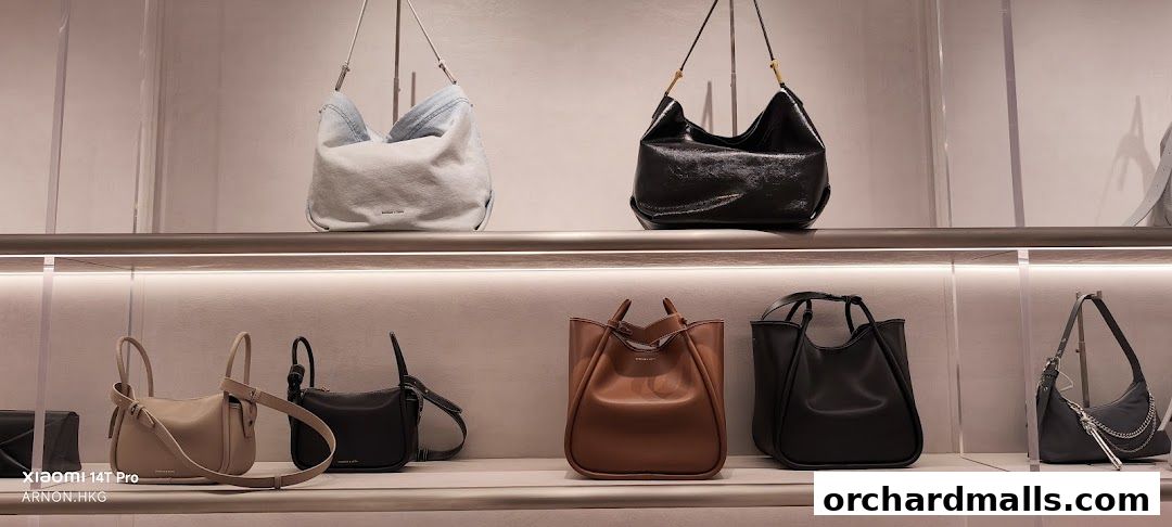 A display of various stylish handbags on shelves in a retail store.