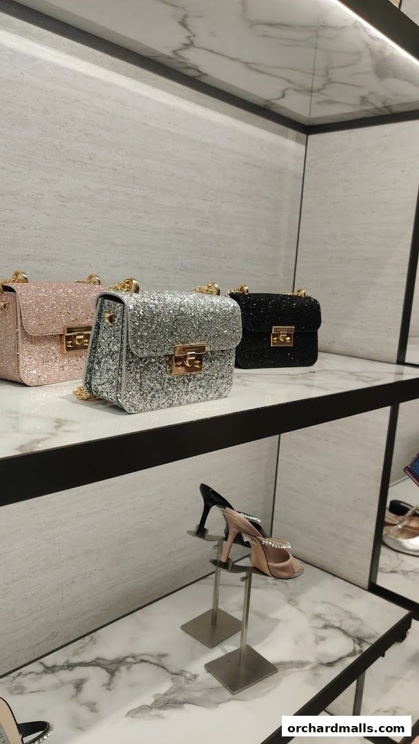 Sparkling handbags and embellished heels displayed on shelves in a retail store.