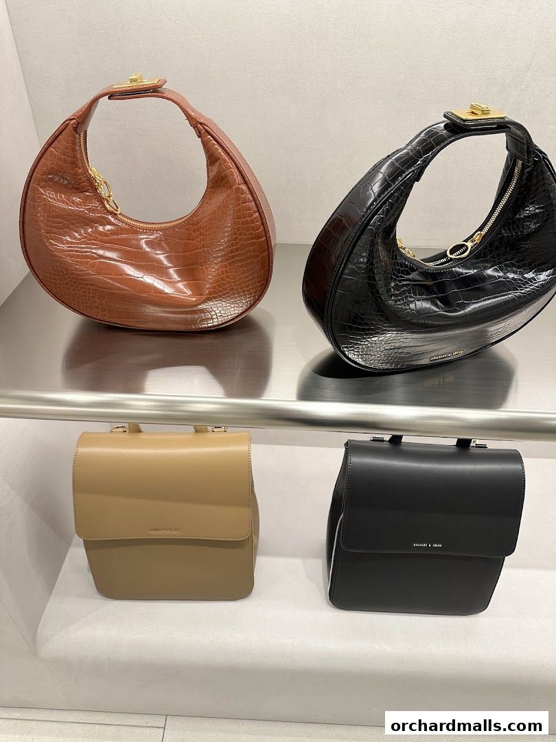 A display of stylish Charles & Keith handbags in various colors and textures.