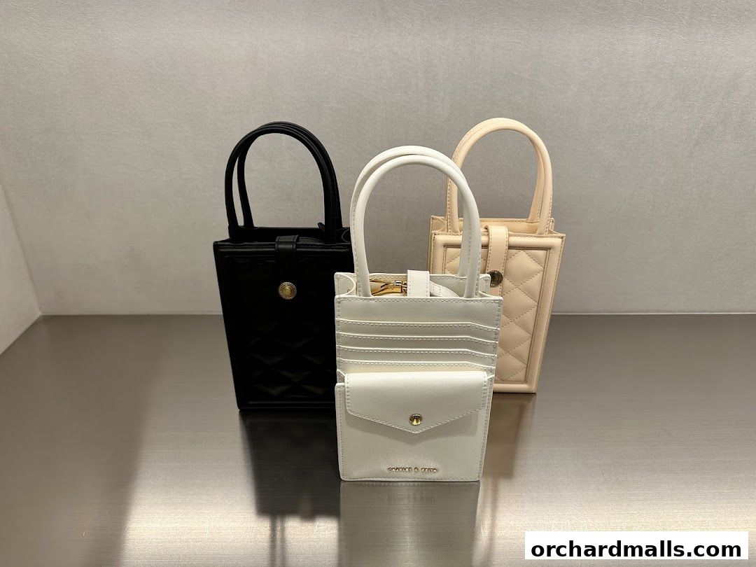 Three stylish handbags in black, white, and beige are displayed on a reflective surface.