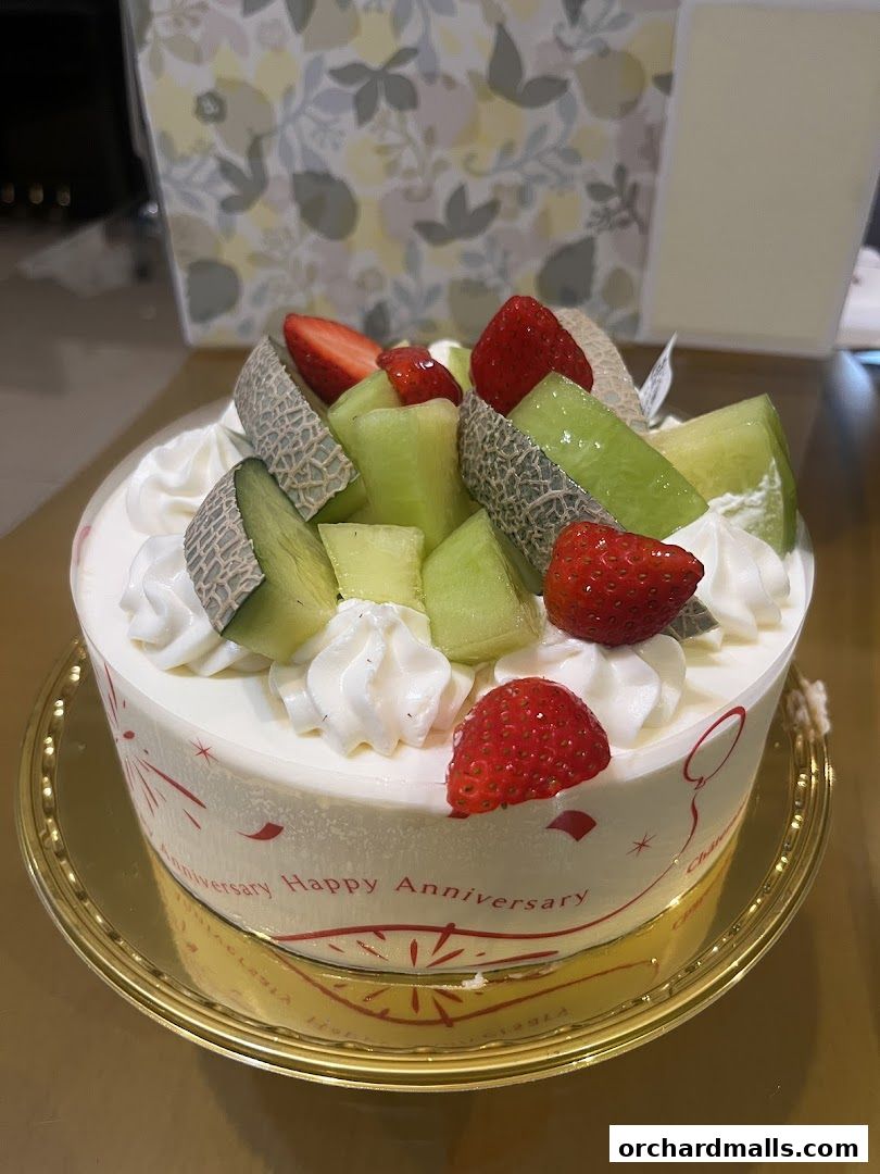A beautifully decorated cake with fresh fruits and whipped cream, perfect for celebrations.