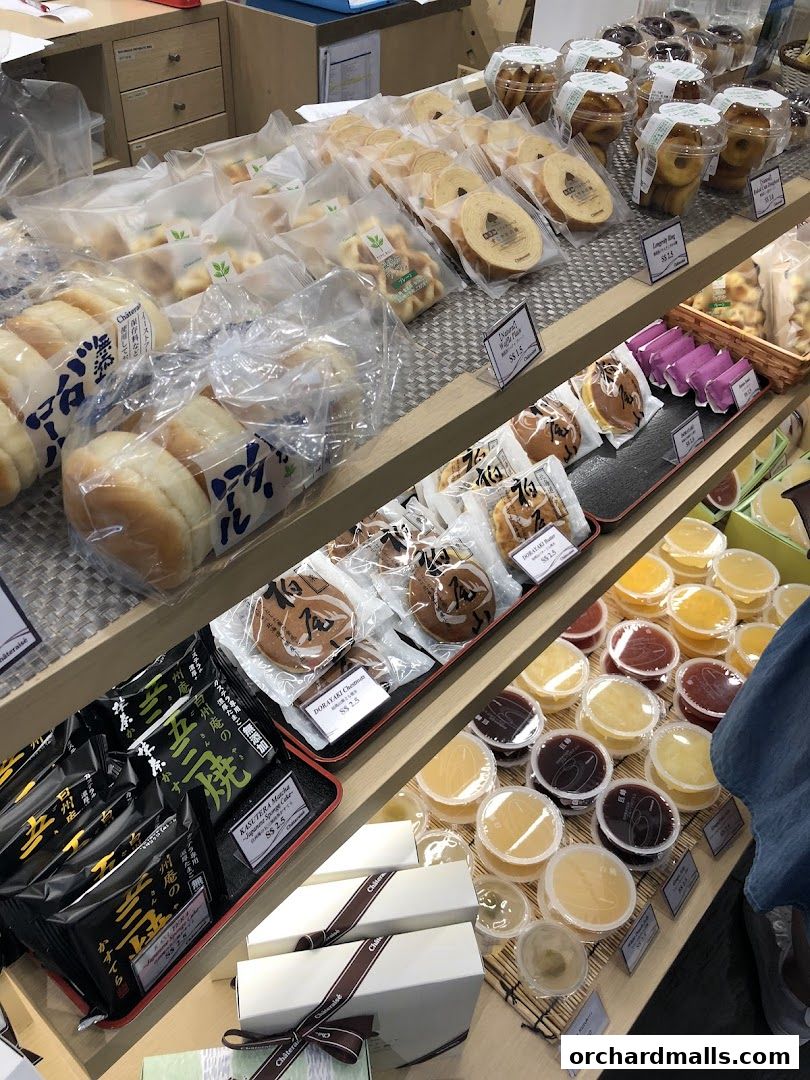 A display of various Japanese pastries and desserts, including cakes, cookies, and jellies.