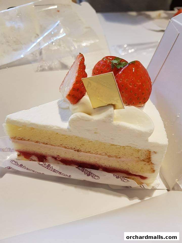 A slice of strawberry shortcake with whipped cream and fresh strawberries.