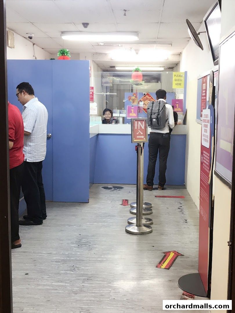 Interior view of a Singapore Pools authorized retailer with customers queuing.