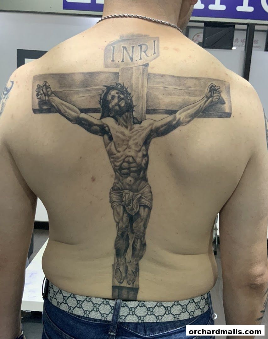 A detailed tattoo of Jesus on the cross covers a person's entire back.