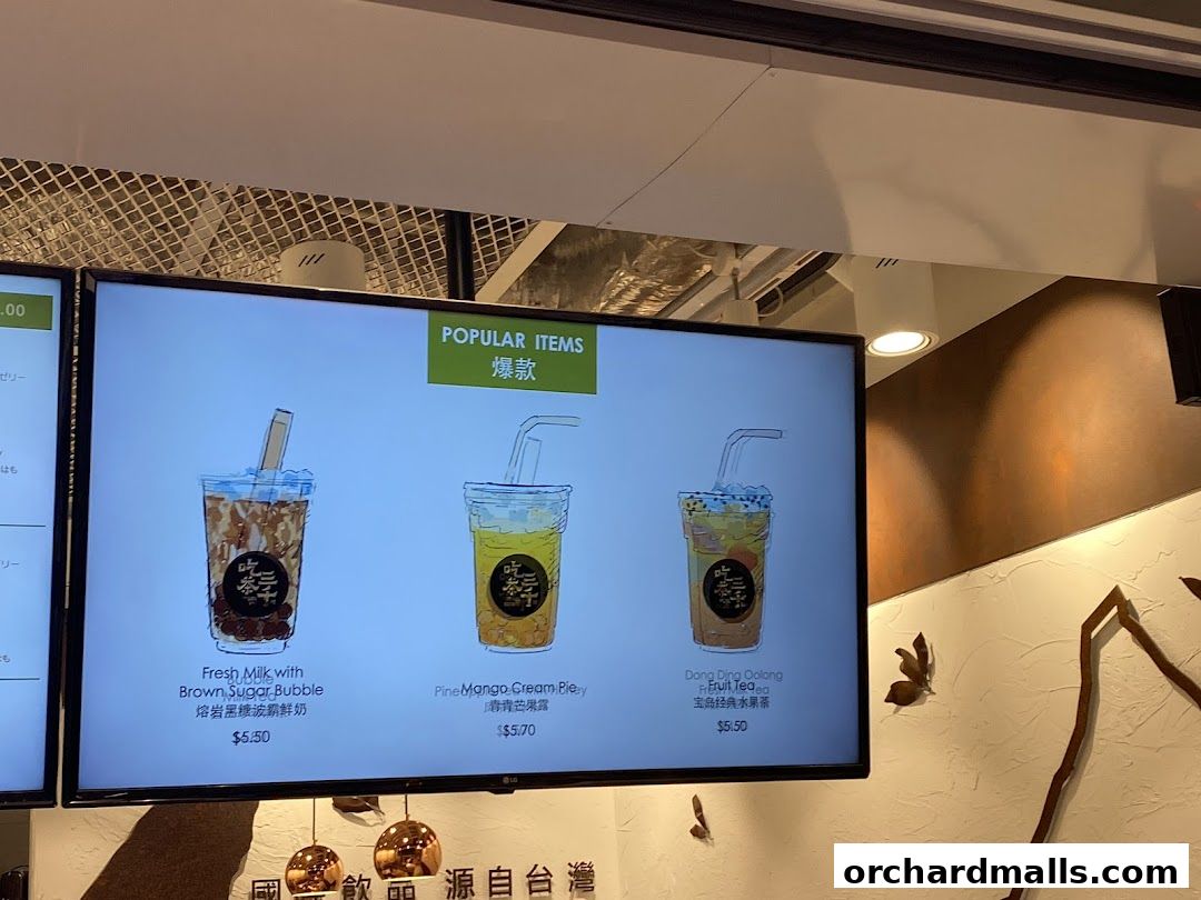 A digital menu board displaying popular bubble tea drinks with illustrations and prices.