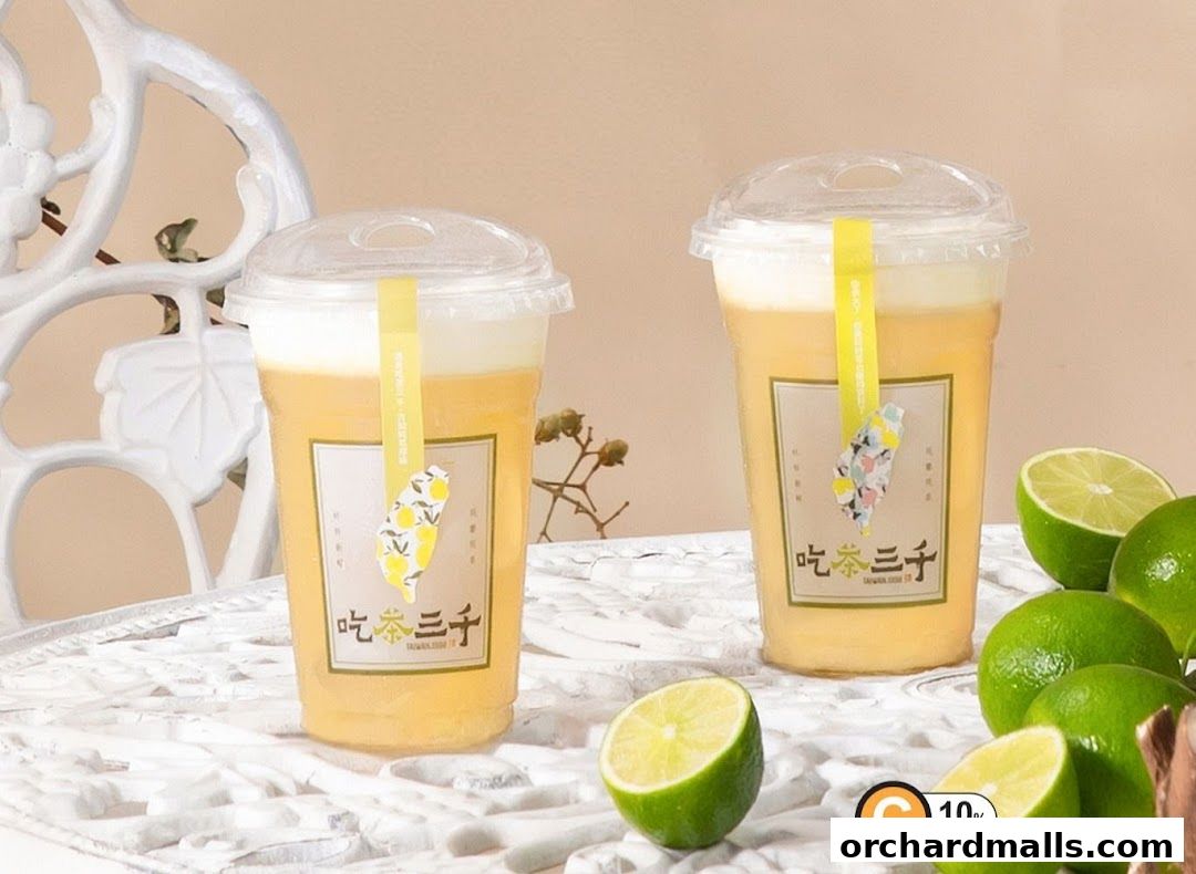 Two cups of CHICHA San Chen bubble tea with limes and a decorative chair.