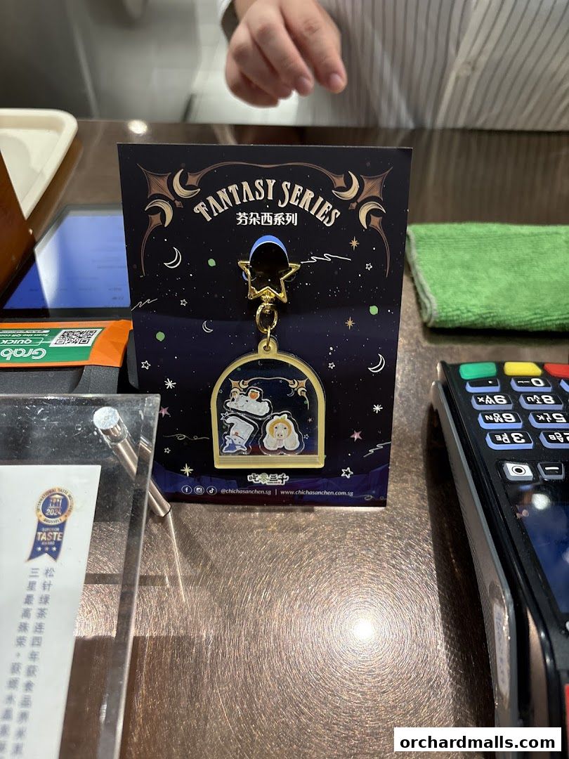 A keychain from CHICHA San Chen's Fantasy Series displayed on a counter.