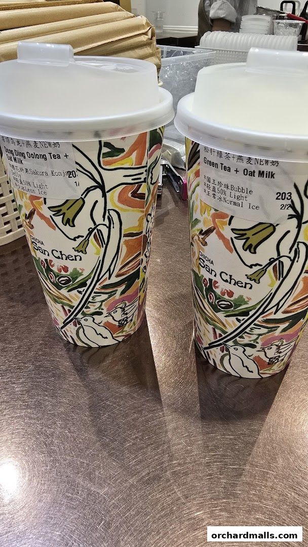 Two cups of bubble tea from CHICHA San Chen with colorful artistic designs.