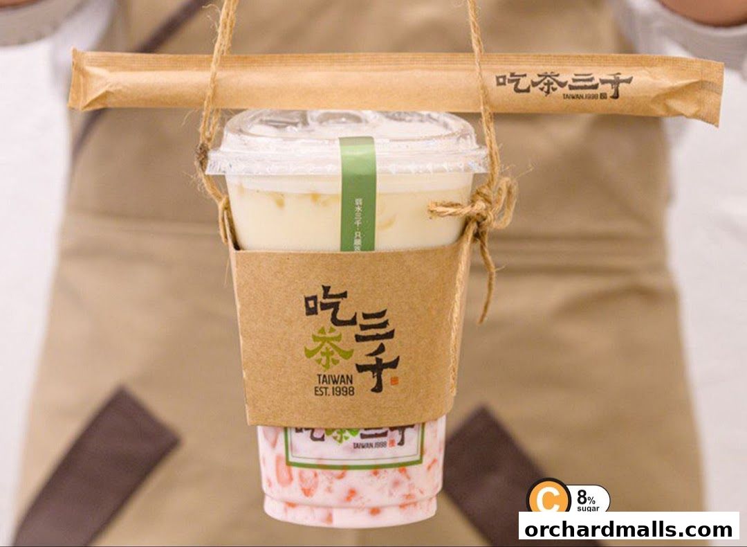 A person holding two drinks from CHICHA San Chen, one with cream and one with fruit.