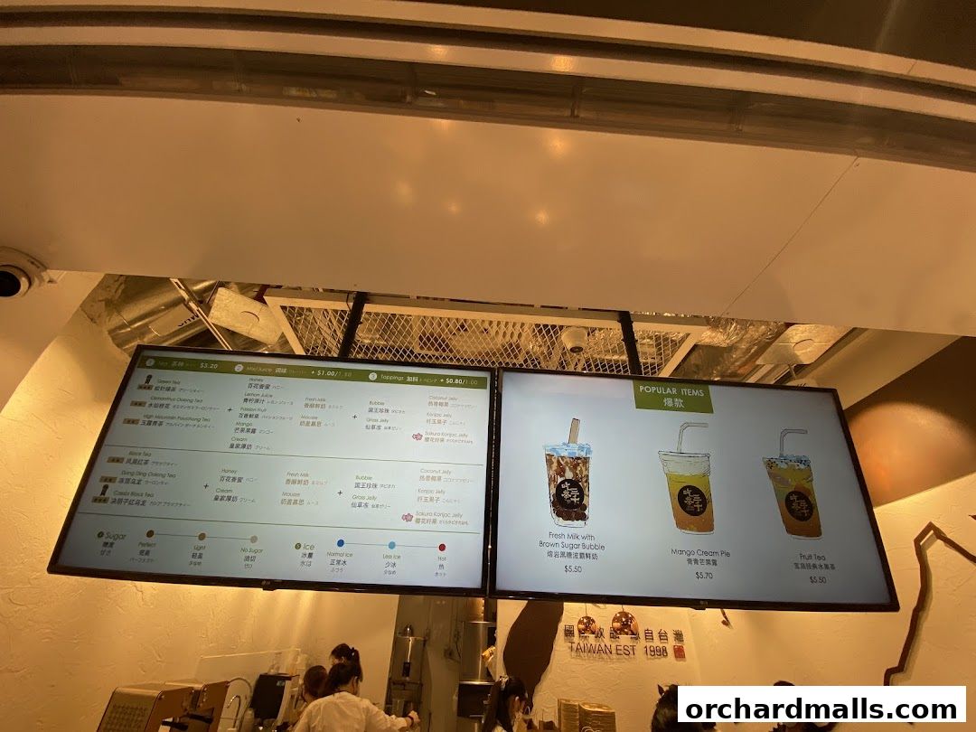 A digital menu board displaying popular bubble tea drinks and customization options.