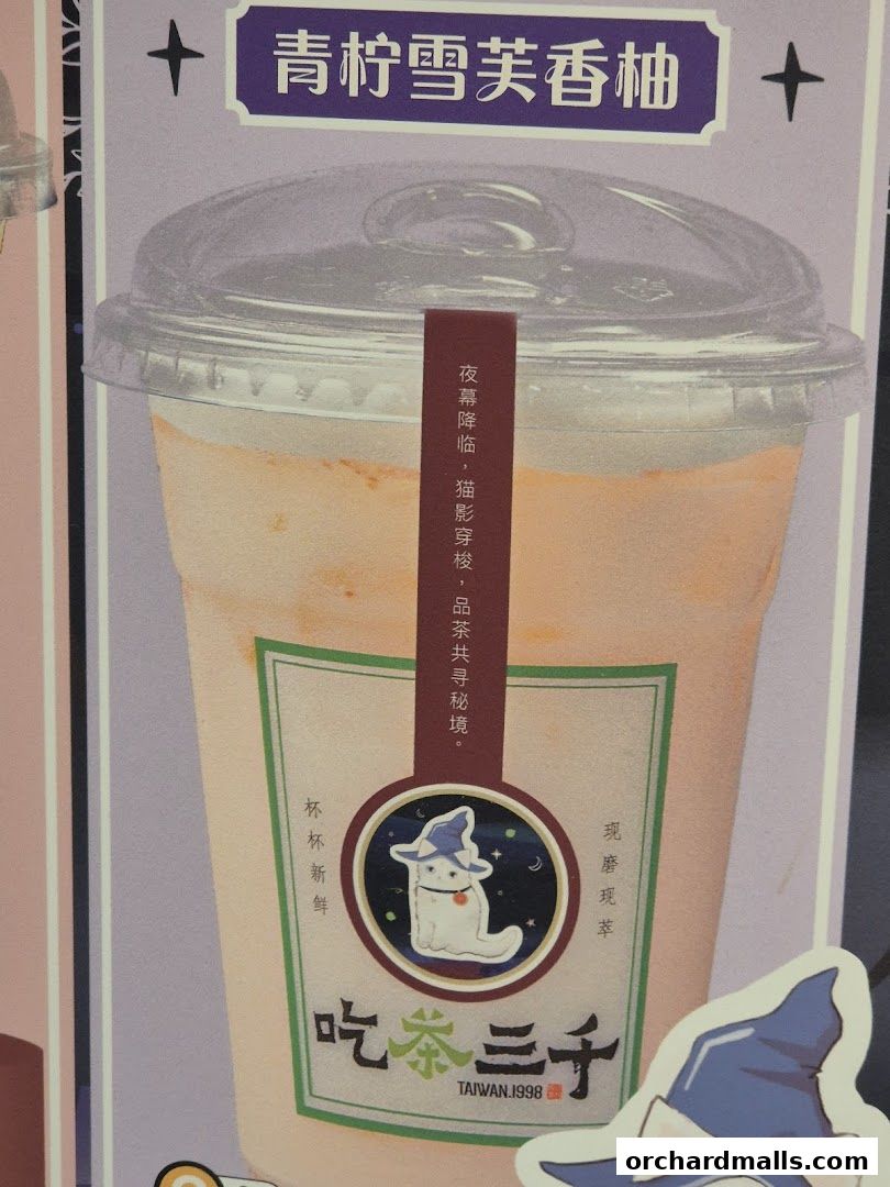 A close-up of a beverage with a cute cat sticker and Chinese text.