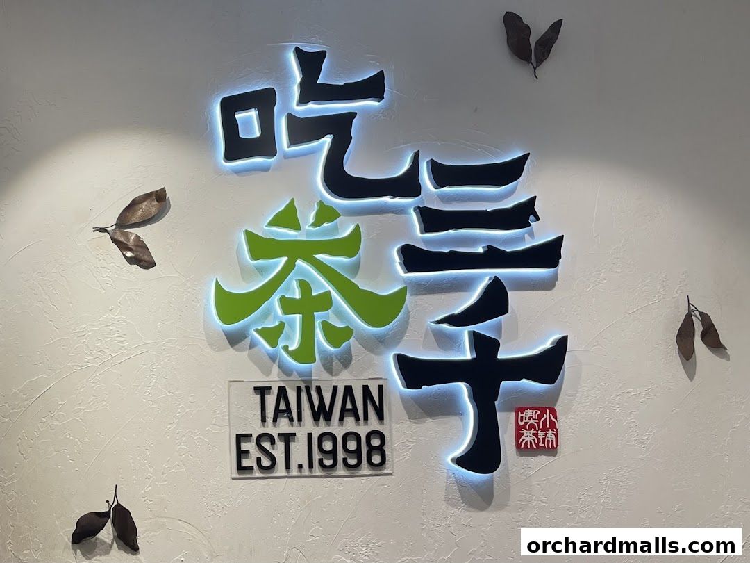 Illuminated Chinese characters and 'Taiwan Est. 1998' sign on a textured wall.