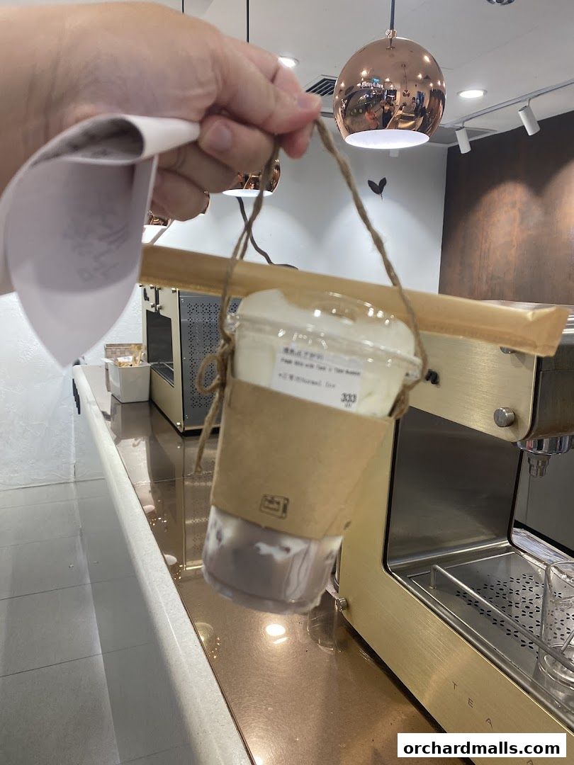 A hand holds a takeaway drink from CHICHA San Chen with a receipt.