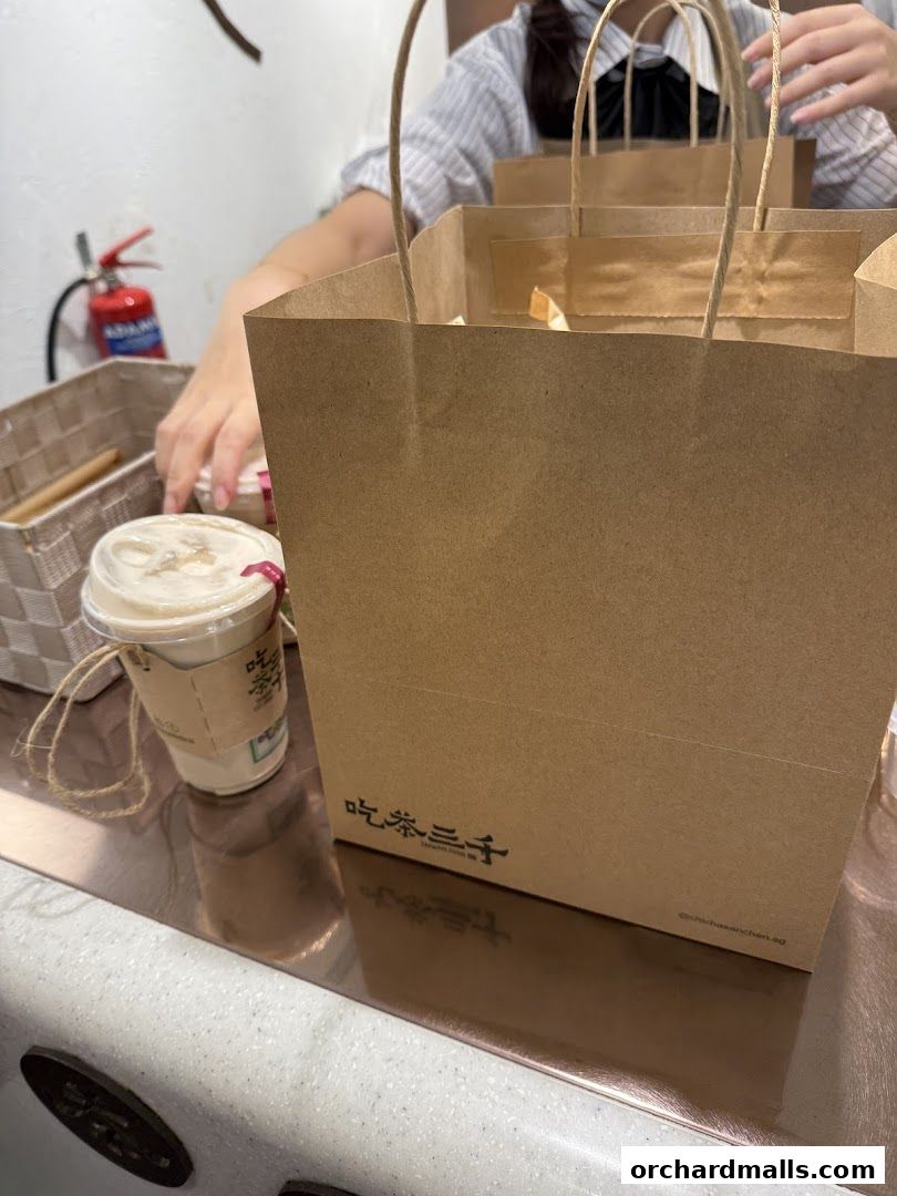 A takeaway drink and shopping bags from CHICHA San Chen.