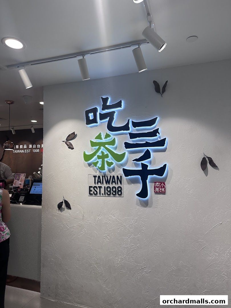 The illuminated logo of CHICHA San Chen, a Taiwanese tea shop, is displayed on a textured wall.