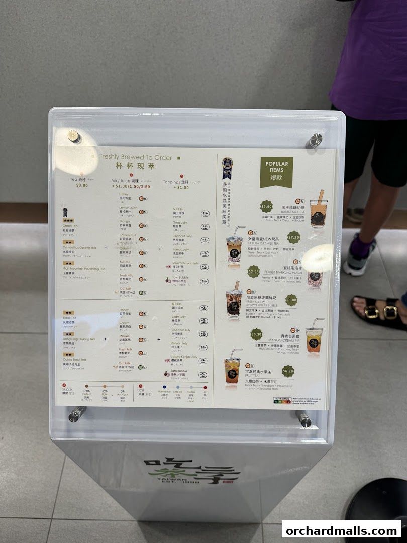 A menu board displaying various bubble tea drinks and toppings with prices.