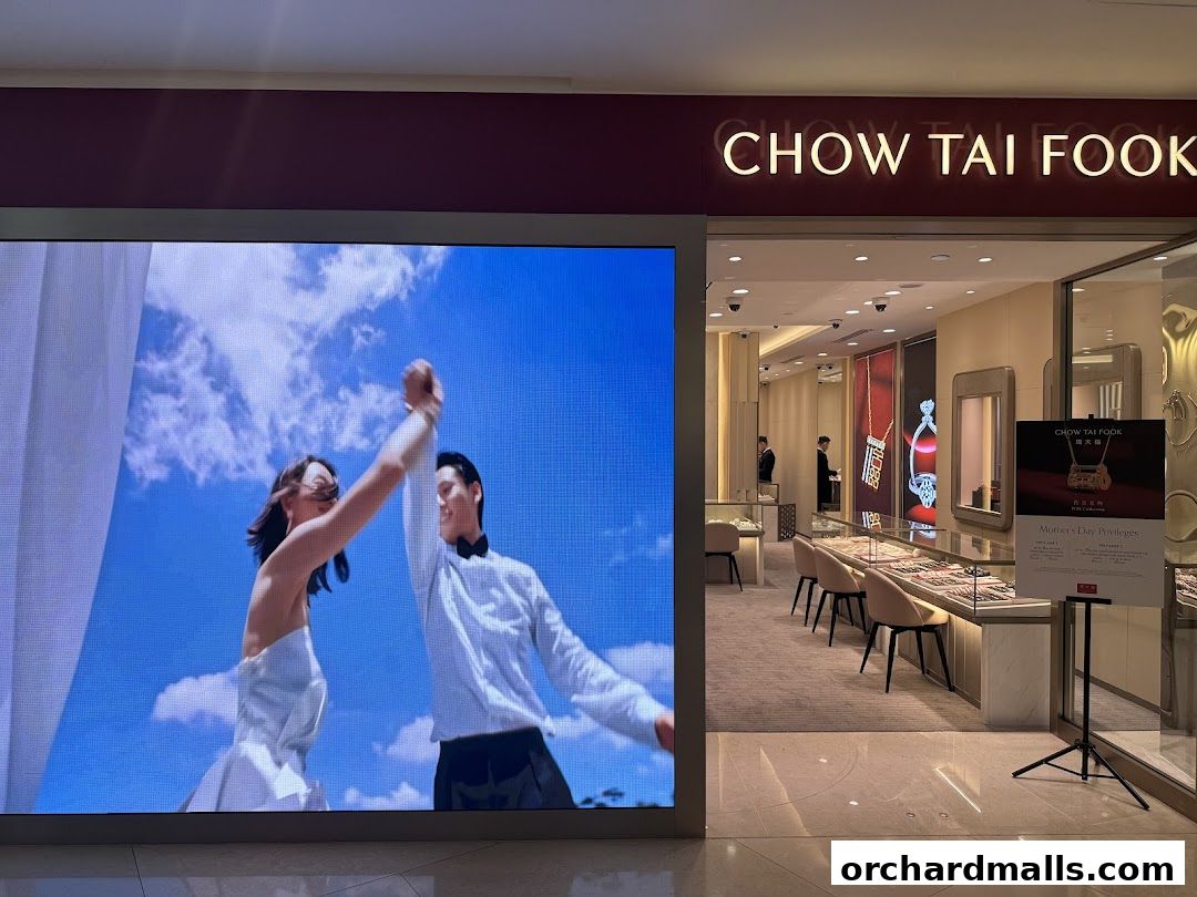 Chow Tai Fook Jewellery store entrance with a large digital display and display cases.