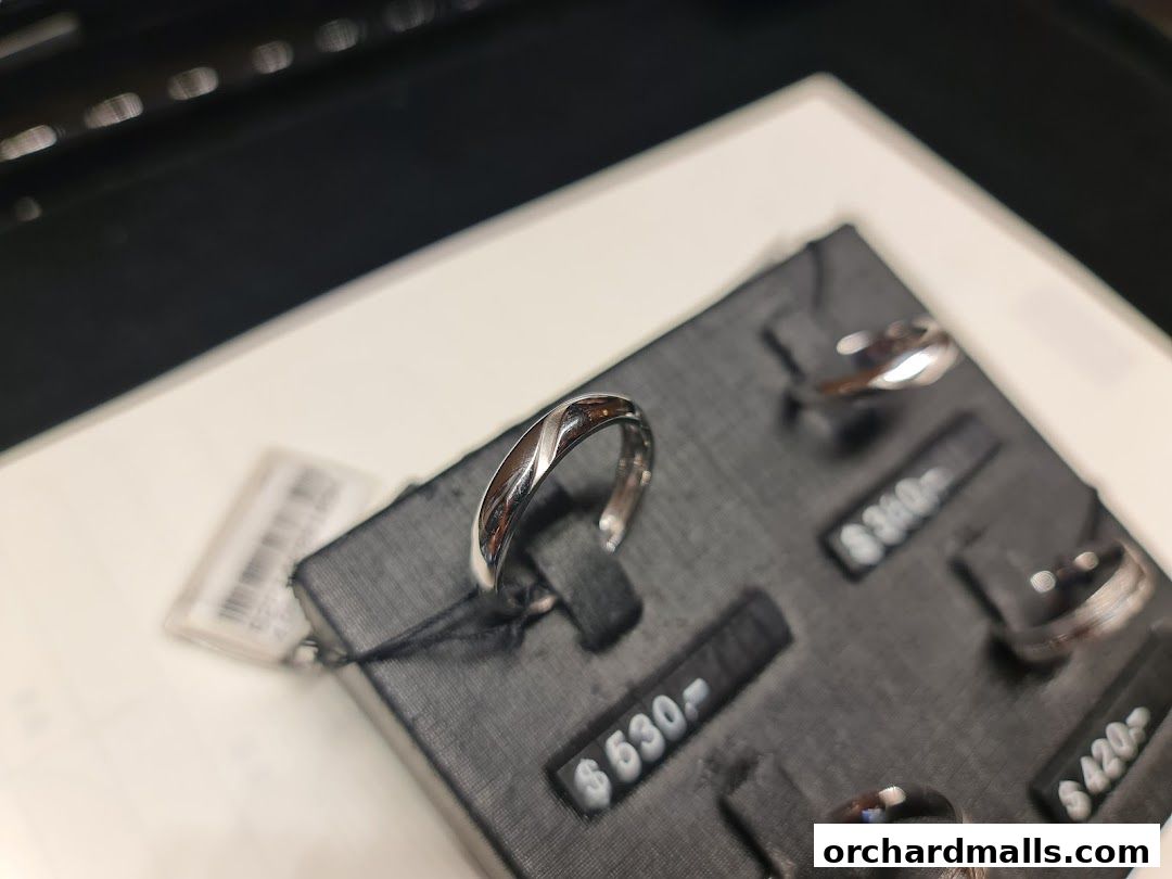 Close-up of elegant silver rings displayed on a black velvet stand with price tags.