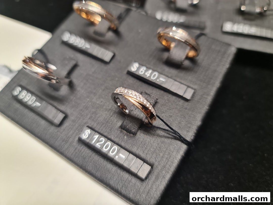 Close-up of various rings displayed on a black velvet stand with price tags.