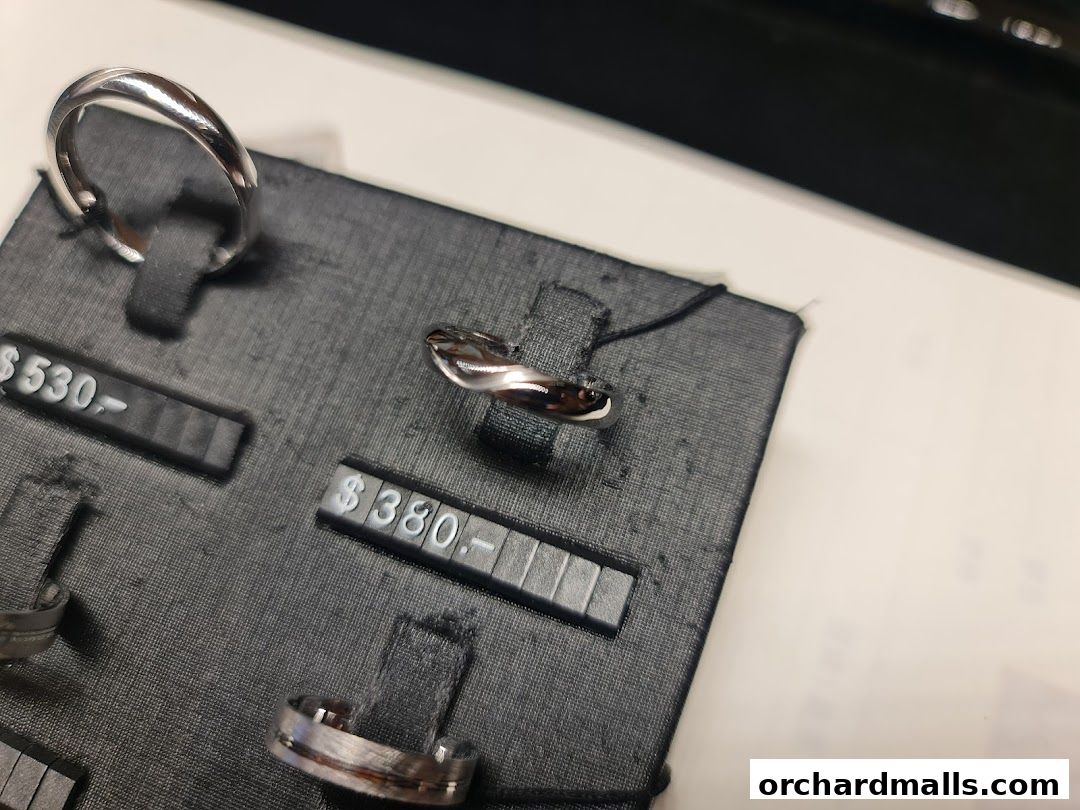Close-up of elegant rings displayed on a black velvet stand with price tags.