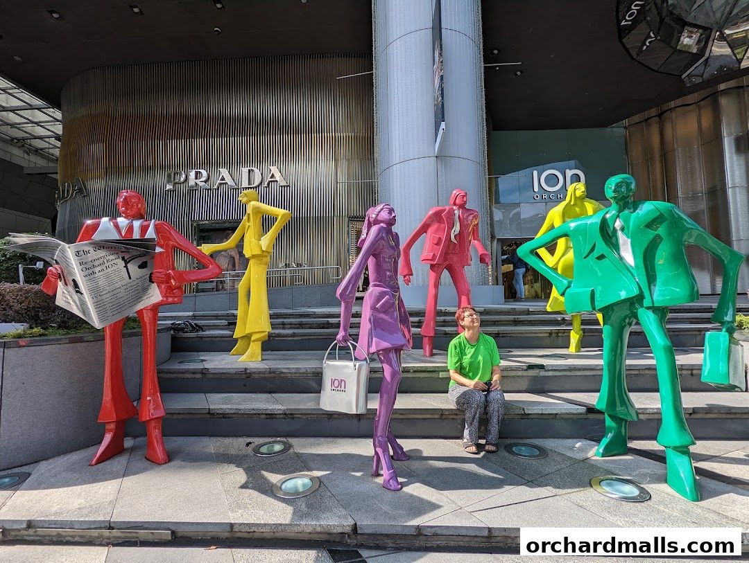 Colorful sculptures of people in business attire stand outside a Prada store at ION Orchard.