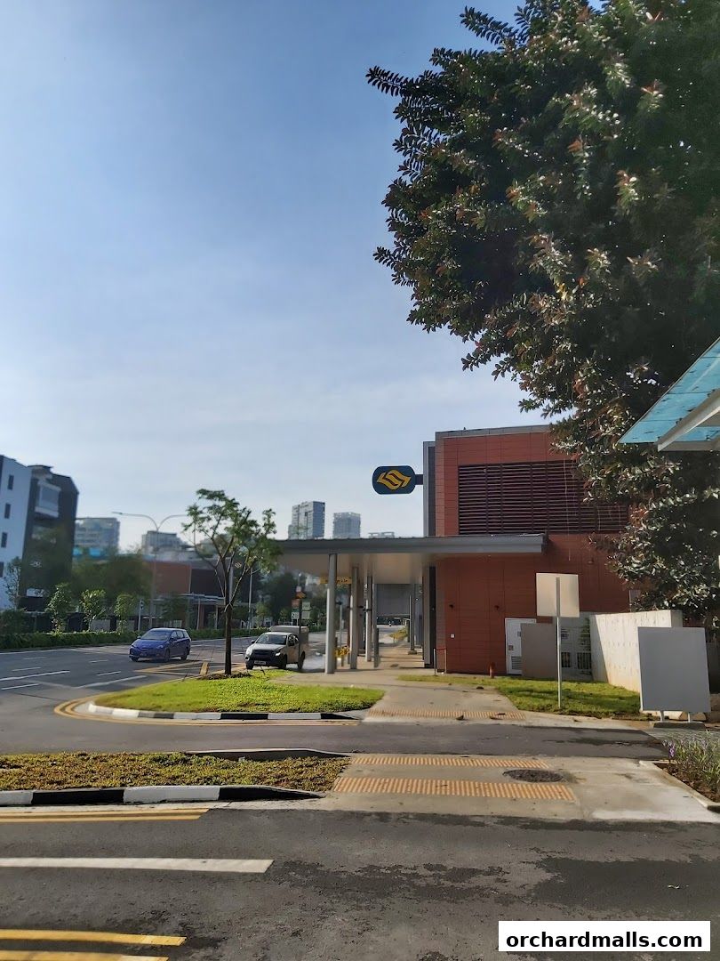 A street view with a covered walkway and a yellow MRT station sign.
