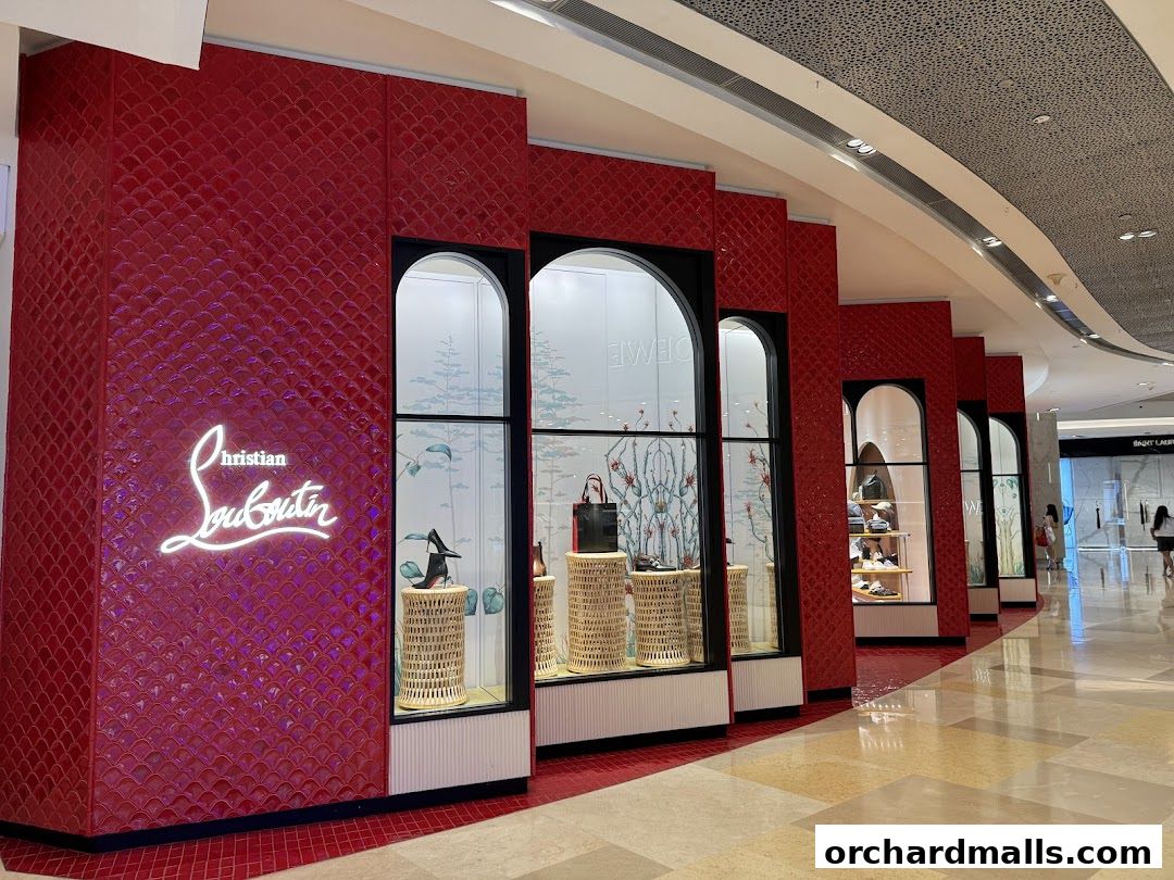 The iconic Christian Louboutin store facade with red tiled walls and illuminated logo.