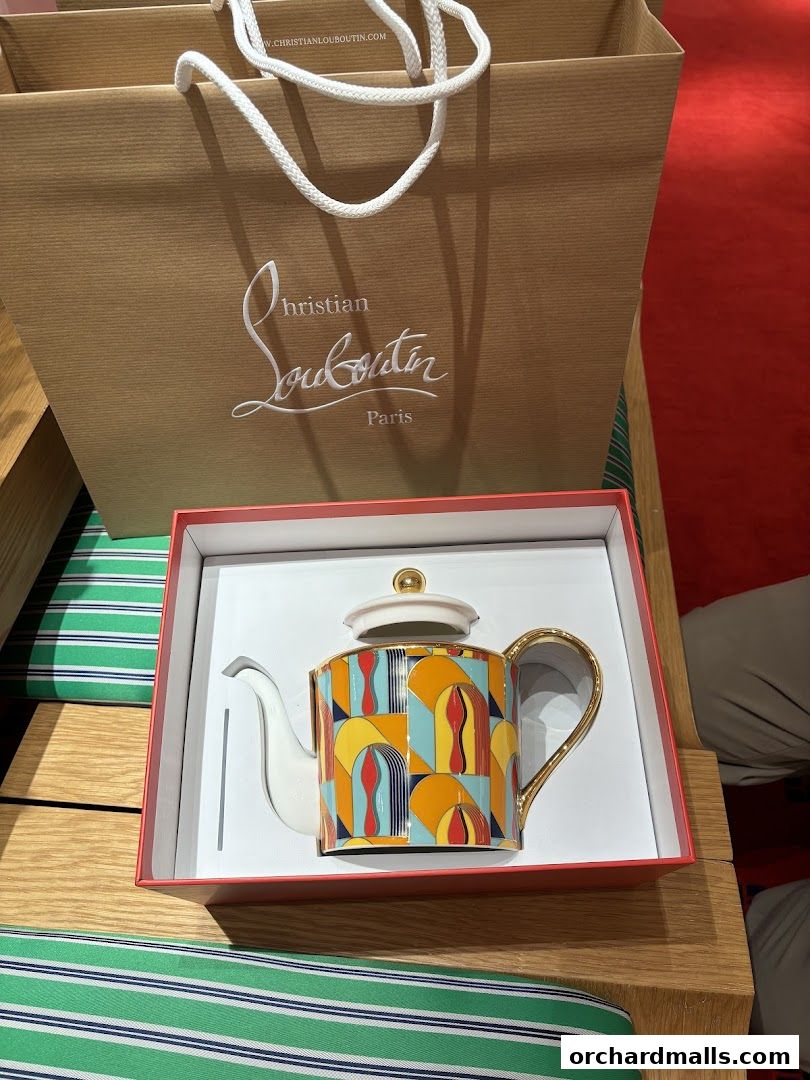 A Christian Louboutin shopping bag and a decorative teapot in a gift box.