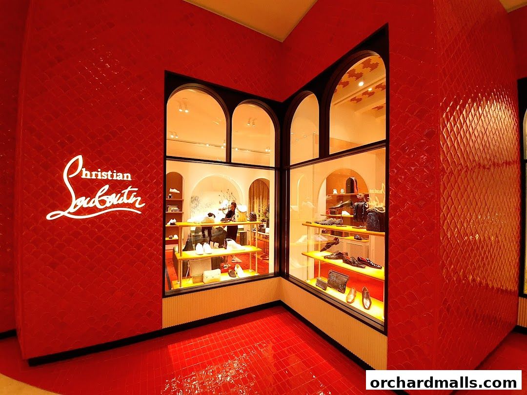 The iconic Christian Louboutin store front with its signature red walls and displays of luxury shoes and bags.